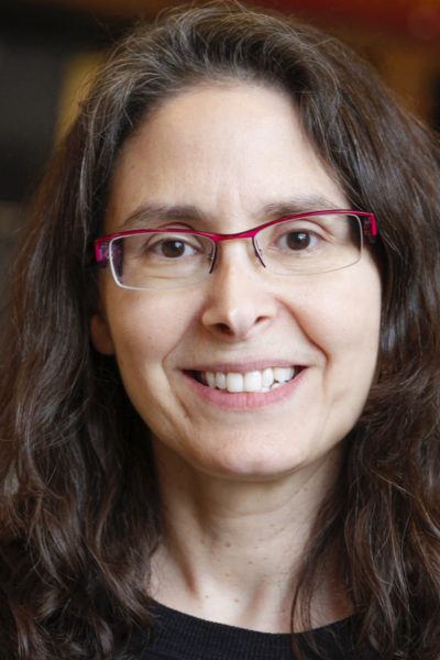 Middle aged White woman with glasses and long brown hair